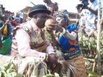 Chief Mumena tastes the first fruit of harvest