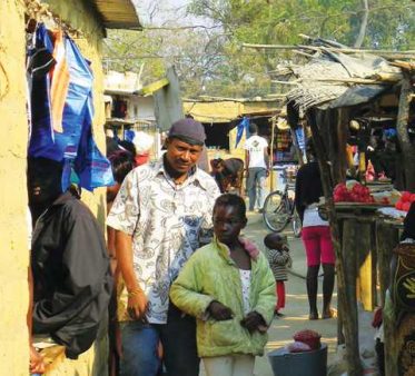 A father and his son beside their kiosk in the Manyama commercial market. The market has become a dense thicket of kiosks that continues to expand adjacent to the T5 Highway.