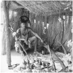 A healer from the Tonga, Zambia, sits in his grass hut