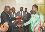 DEPUTY Minister of Youth and Sport Christopher Mulenga congratulates bronze medalist Boas Munyonga on arrival at Kenneth Kaunda International Airport in Lusaka this afternoon. Looking on are National Sports Council of Zambia chairperson Mwamba Kalenga (second left) and Judo Association president Alfred Foloko. – Picture by CHANDA MWENYA.