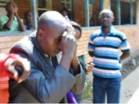 HOLY Fire Christian Ministry Church Bishop Dominic Nyondo shielding his face from cameras at the Kitwe magistrate’s court after he appeared for defilement yesterday. Picture by MOFFAT CHAZINGWA.