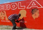 A Liberian man paints on a wall as part of a sensitisation programme about the deadly Ebola virus. Photograph: Ahmed Jallanzo/EPA