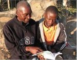 MB photo by James Langston Passmore Hacaba, who has endured persecution for his faith, discusses a Bible verse with Tonga believer Maxwell Mwaanga.