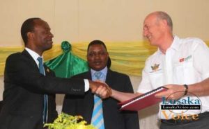The Lusaka City Mayor Mulenga Sata exchanging documents with the ZANACO MD Dick Bruce while looking on is Deputy Minister of Local Government and Housing Nicolas Banda during launch between Zanaco and Lusaka City Council Direct Debit and Credit Clearing (DDACC) at the Nkatindi Hall