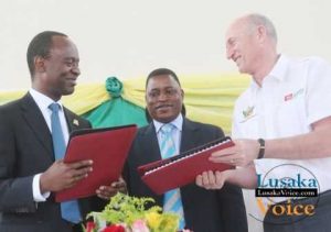 The Lusaka City Mayor Mulenga Sata exchanging documents with the ZANACO MD Dick Bruce while looking on is Deputy Minister of Local Government and Housing Nicolas Banda during launch between Zanaco and Lusaka City Council Direct Debit and Credit Clearing (DDACC) at the Nkatindi Hall