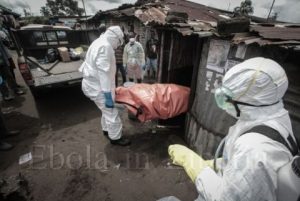 Dressed in protective clothing, Garmai Sumo and his colleagues carry the body of 40-year-old Mary Nyanforh from her house - Ebola crisis in Liberia