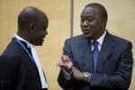 enya's President Uhuru Kenyatta (R) speaks to a member of his defence team as he appears before the International Criminal Court in The Hague October 8, 2014.