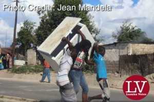 Some guys spotted along Matero- Lilanda carrying a fridge believed to have been looted. . - Lusakavoice.com
