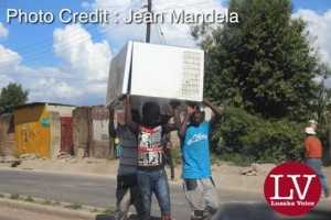 Some guys spotted along Matero- Lilanda carrying a fridge believed to have been looted. . - Lusakavoice.com