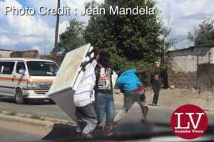 Some guys spotted along Matero- Lilanda carrying a fridge believed to have been looted. . - Lusakavoice.com